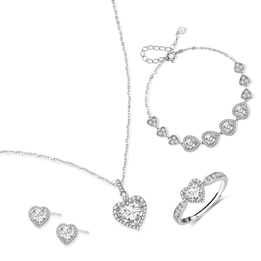 Complete jewelry set with heart-shaped sterling silver pieces featuring brilliant moissanite stones on white background.