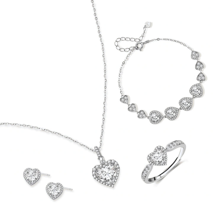 Complete jewelry set with heart-shaped sterling silver pieces featuring brilliant moissanite stones on white background.