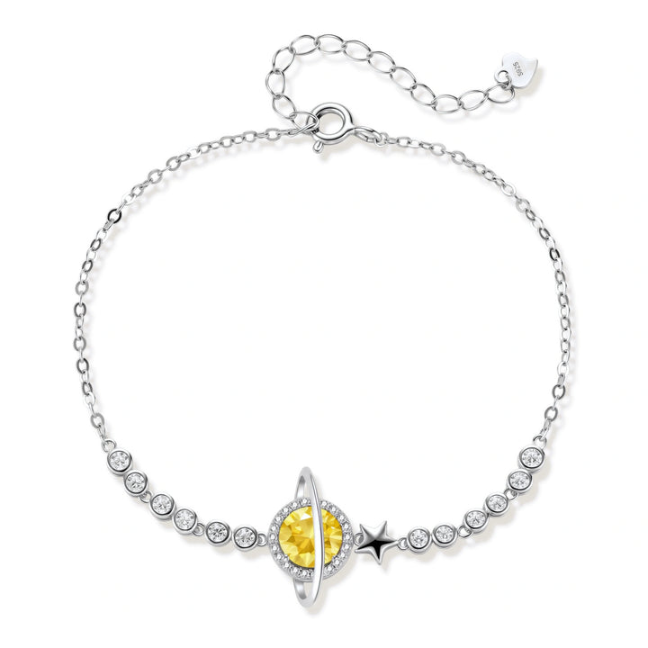 Sterling silver bracelet with yellow moissanite centerpiece in oval setting, crystal chain, and star charm on white background.